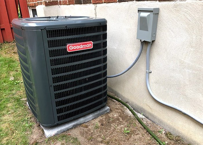 Outdoor air conditioner service beside a home